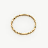 Gold bangle with a twisted design on a white background