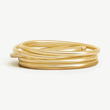 Stack of five 14k solid gold Namiri Bangles with polished finish, arranged on a white background