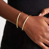 Model wearing two 14k solid gold Namiri Bangles on wrist, highlighting their polished finish and minimalist design.