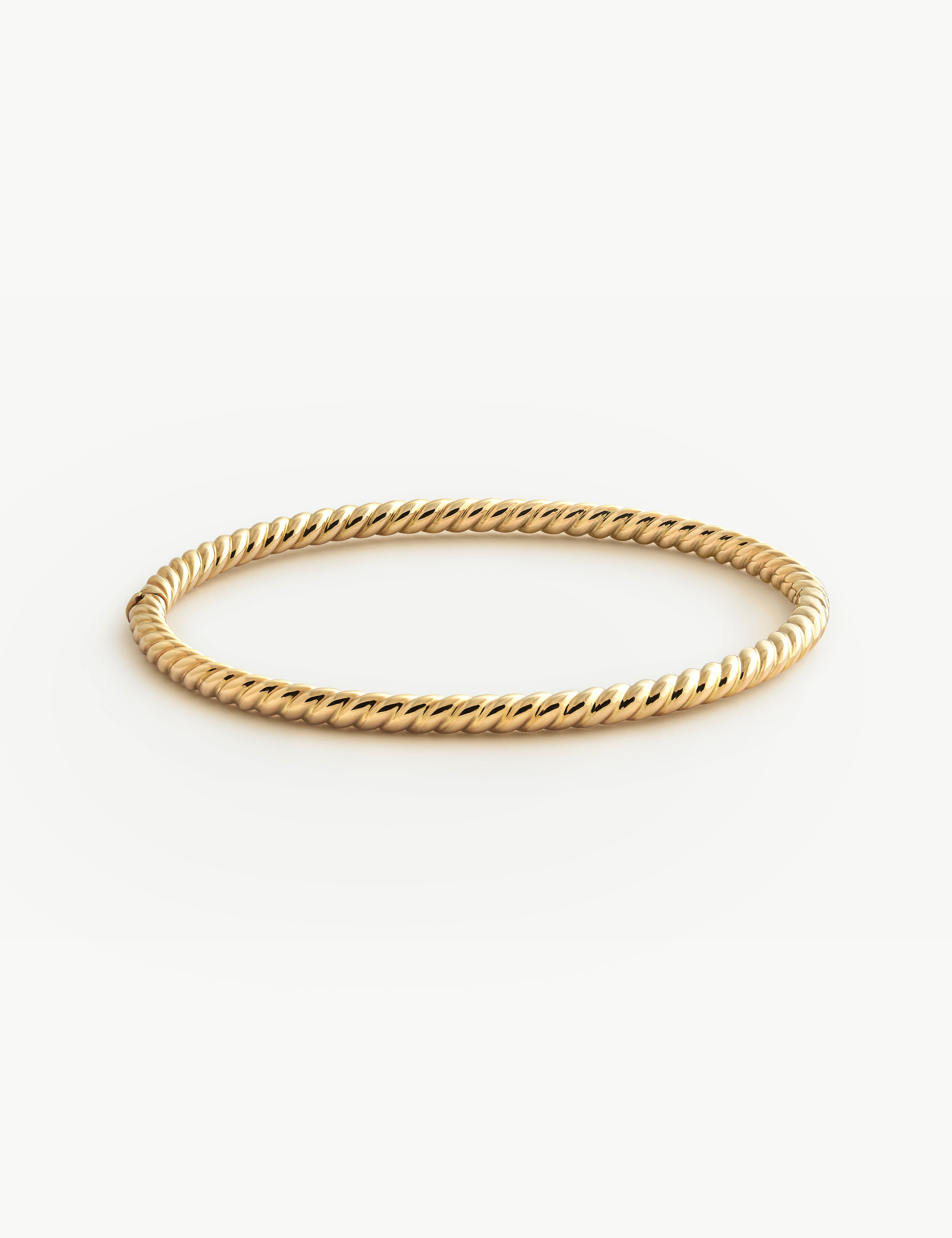 Solid Gold twist bracelet on a white background