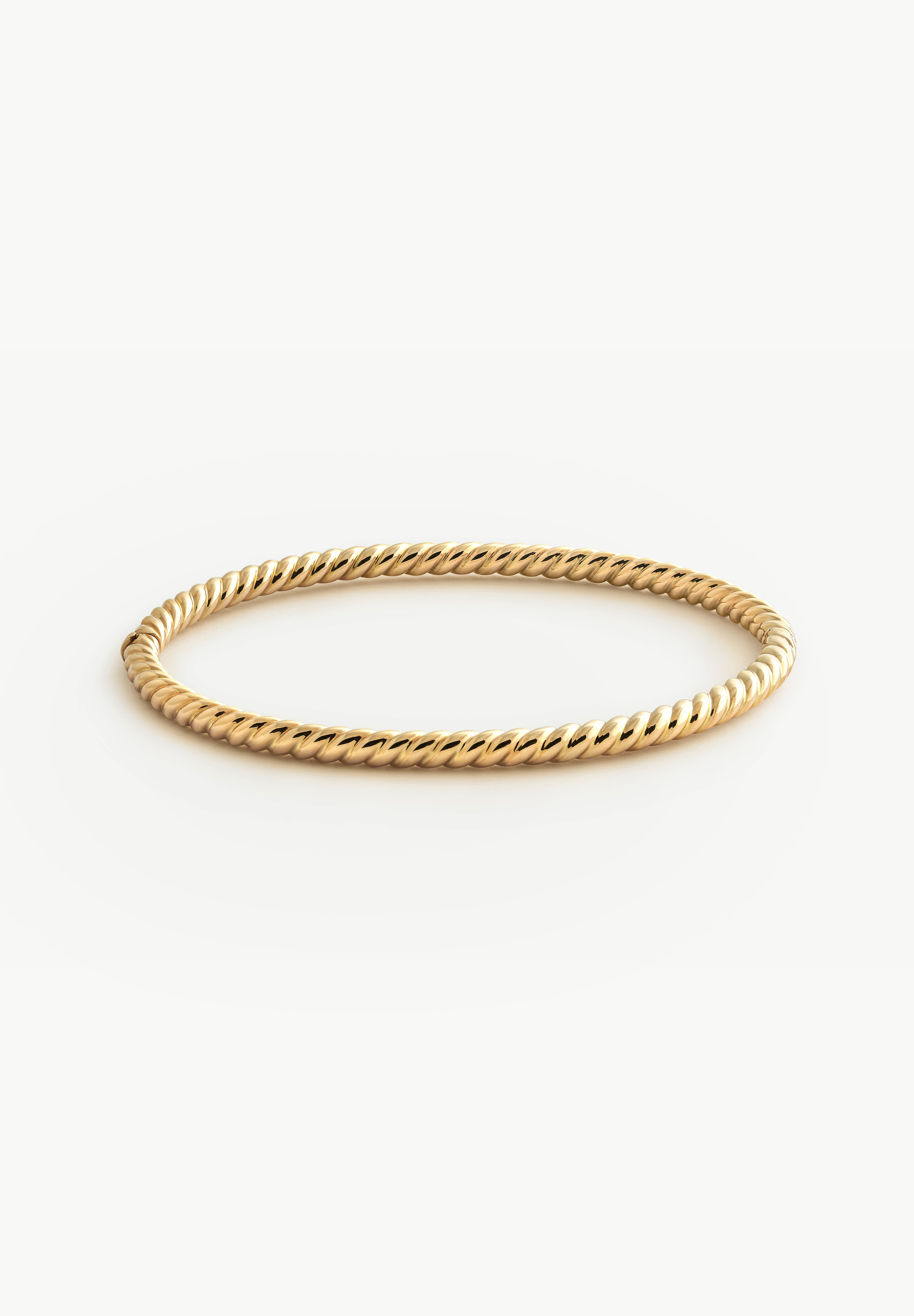Solid Gold twist bracelet on a white background